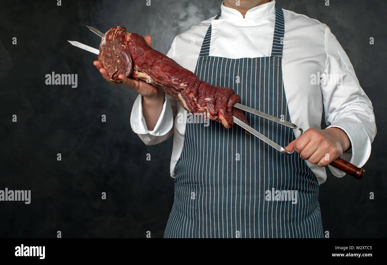 Lo chef senza volto tenendo gli spiedini di carne Foto Stock