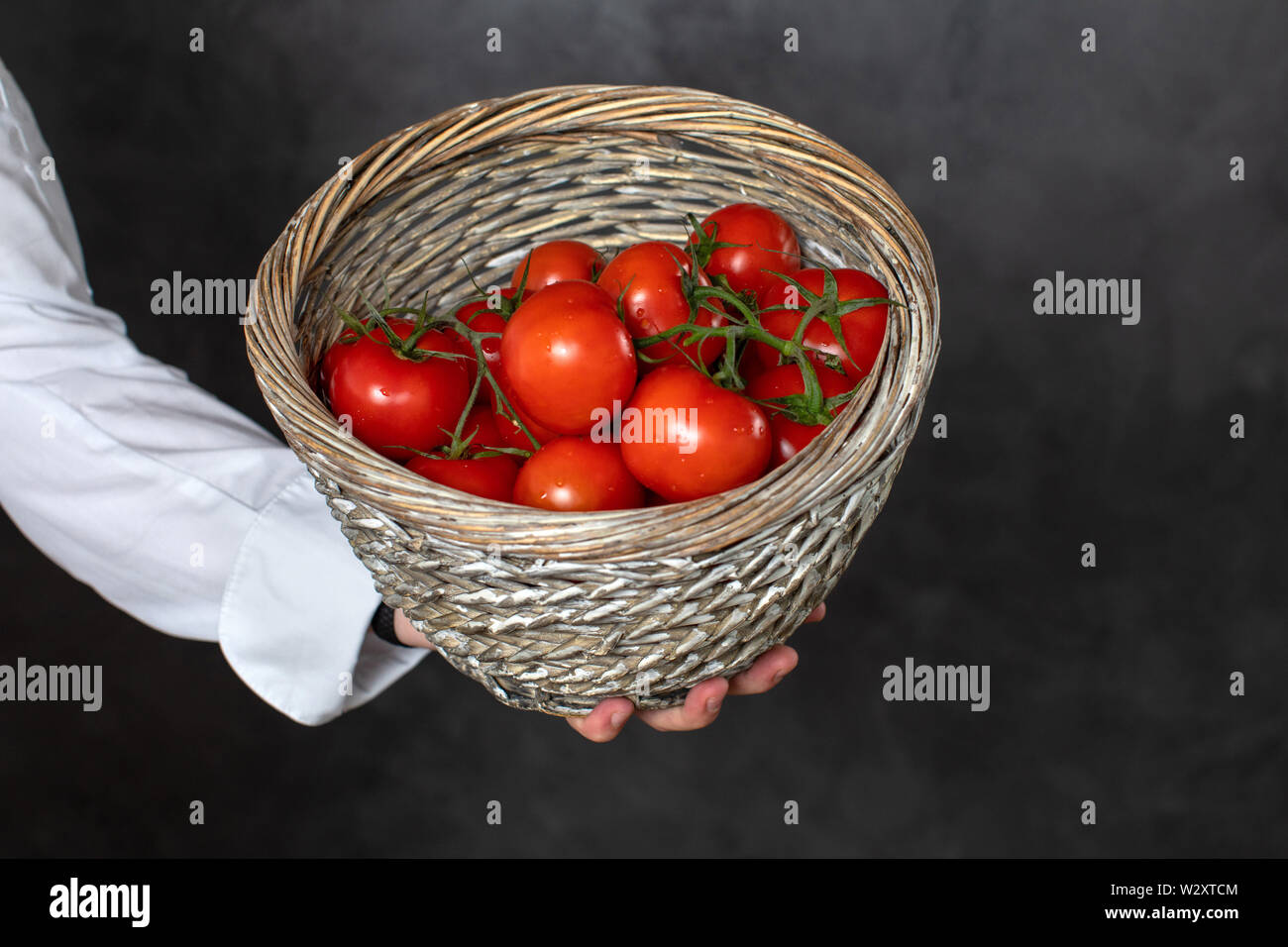 Lo chef senza volto cestello di contenimento con pomodori maturi Foto Stock