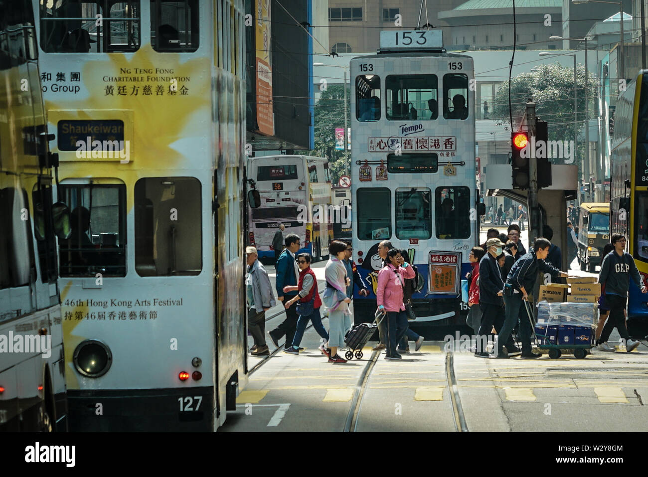 Isola di Hong Kong, Hong Kong-13th Marzo 2019: strada trafficata scena con i tram e le persone che attraversano la strada. Foto Stock