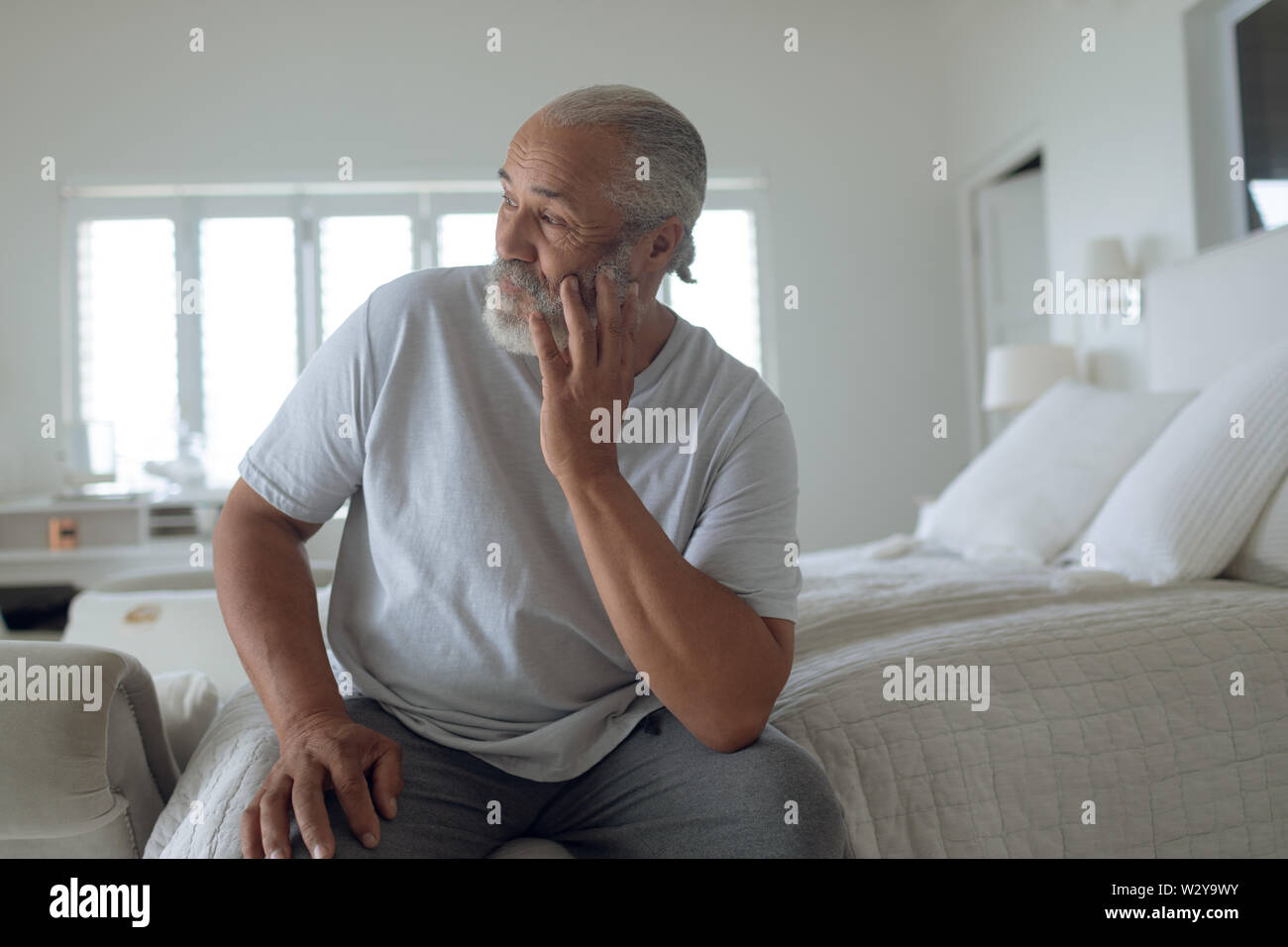 Uomo seduto sul letto Foto Stock