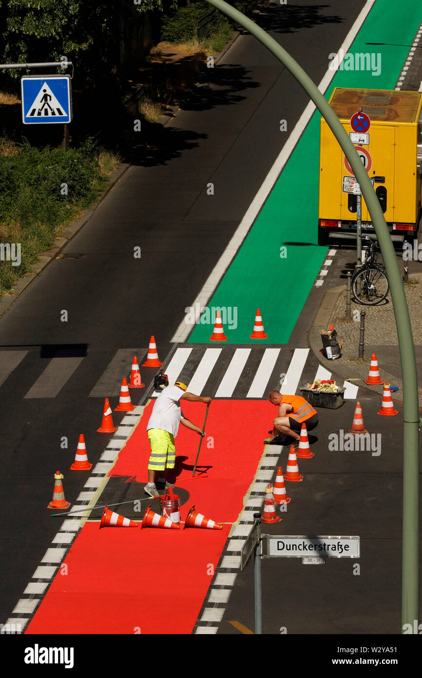 Arbeiter beim aufmalen von grünen Fahrradwegen a Berlino Foto Stock