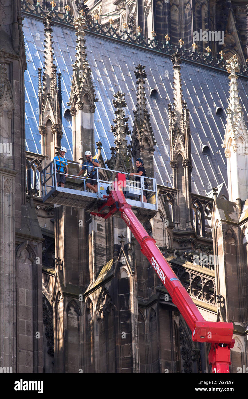 Lavoratori su una piattaforma di lavoro aerea presso il lato nord della cattedrale di Colonia, Germania. Arbeiter auf einer LKW-Arbeitsbuehne an der Nordseite des fare Foto Stock