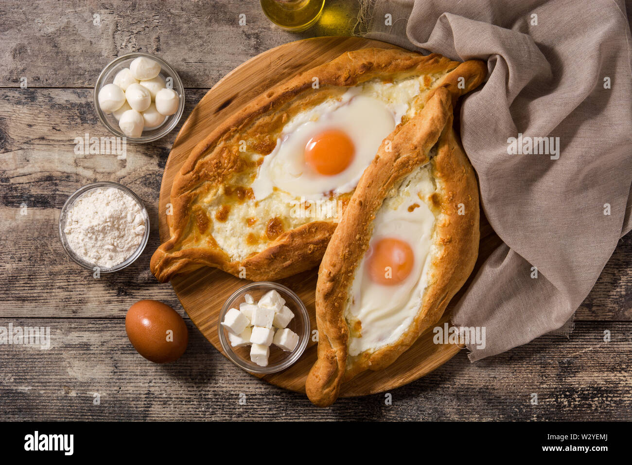 Tradizionale georgiano Adjarian khachapuri con formaggio e uova su un tavolo di legno. Vista superiore Foto Stock