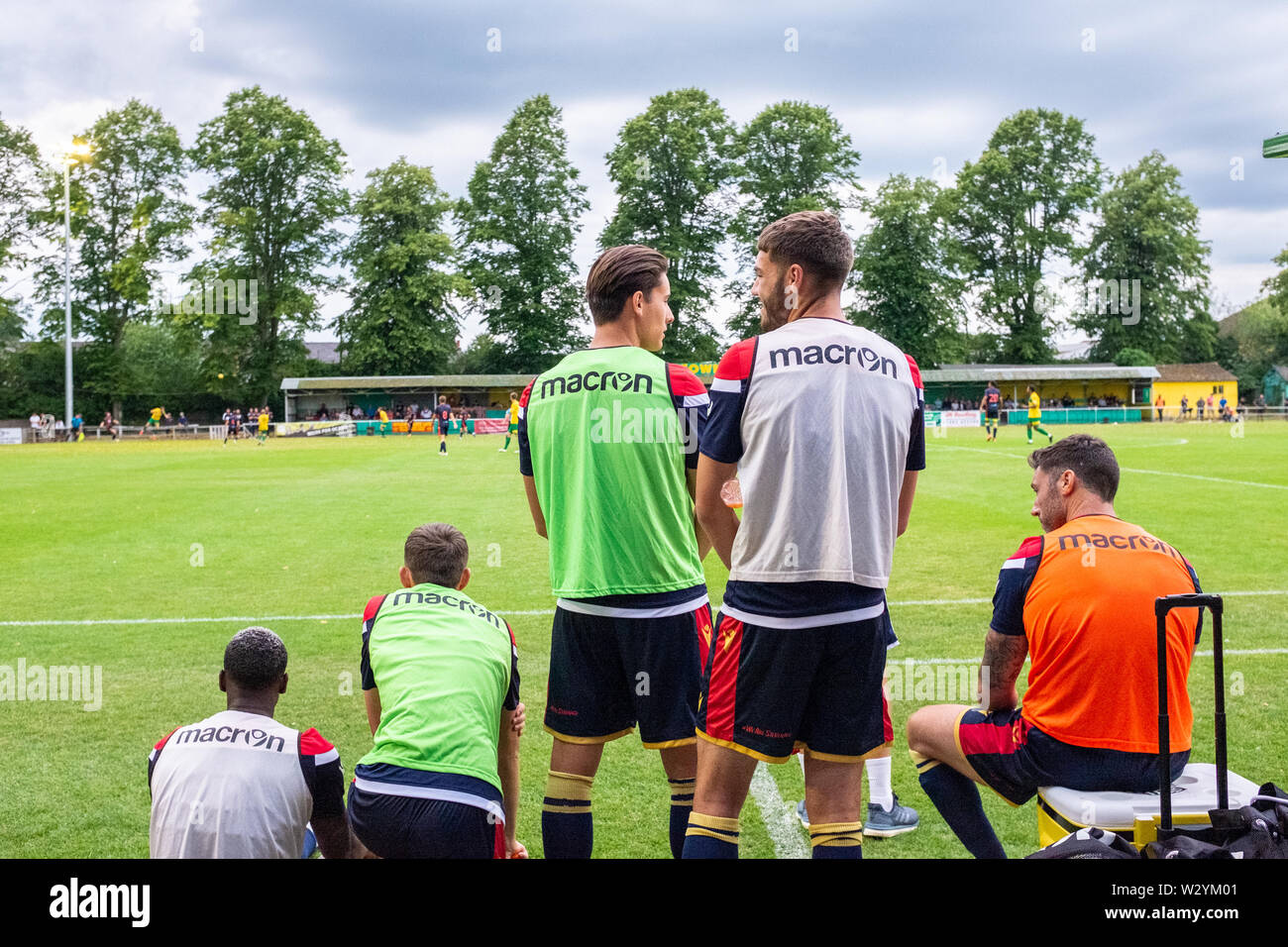 Sostituire i giocatori di calcio in chat e il riscaldamento sul margine durante il match in campionato inferiore e non la massa di lega Foto Stock