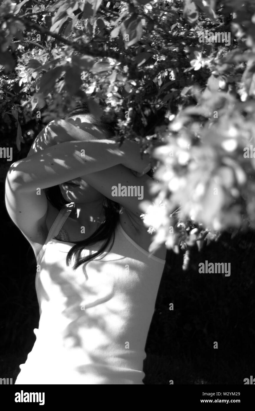 Un autoritratto con un albero di blossom pur nascondendo la mia faccia. Foto Stock