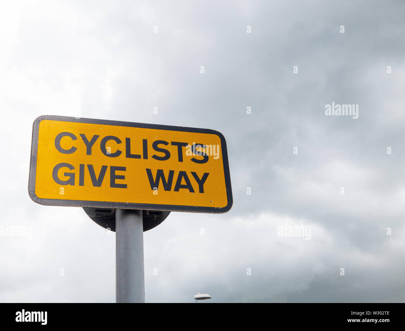 Un cartello stradale che raccontano i ciclisti per dare modo. Foto Stock