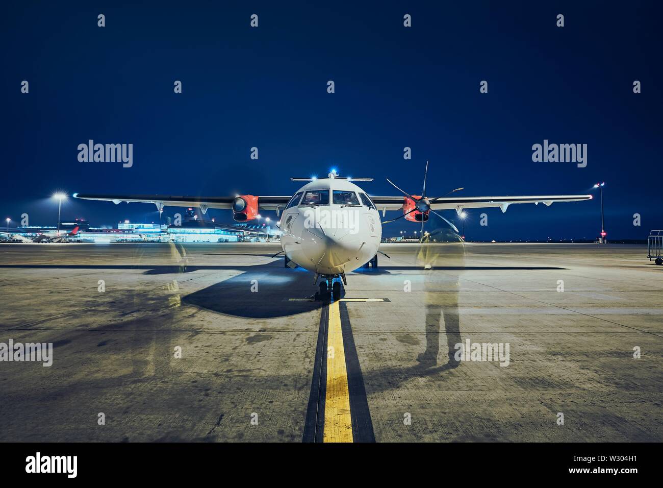 Avviamento dei motori di aerei a turboelica prima del decollo contro l aeroporto di notte (lunga esposizione). Foto Stock