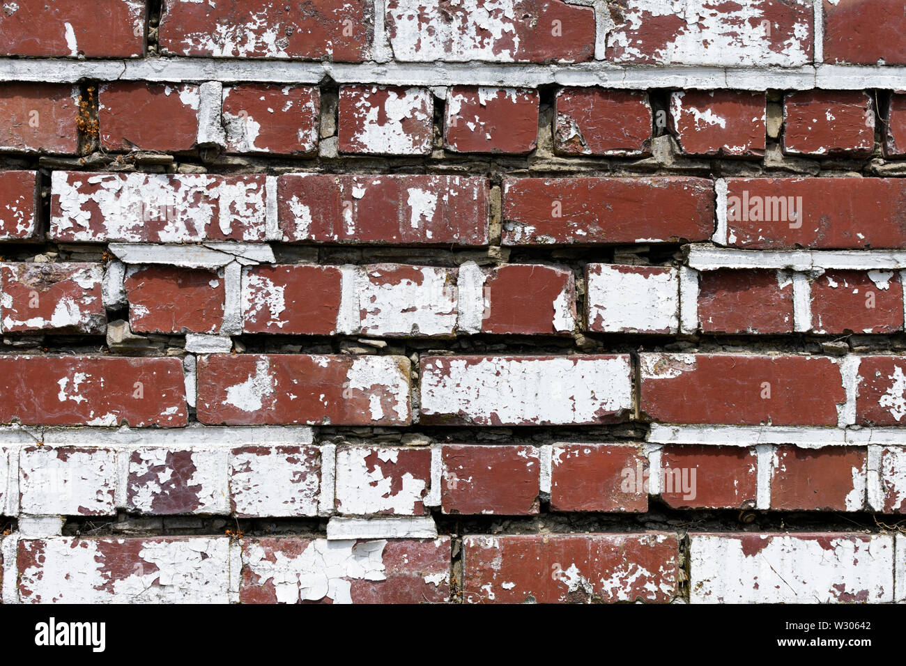 Rosso di un muro di mattoni con la vecchia vernice bianca che si stacca bella texture e utilizzare come sfondo Foto Stock