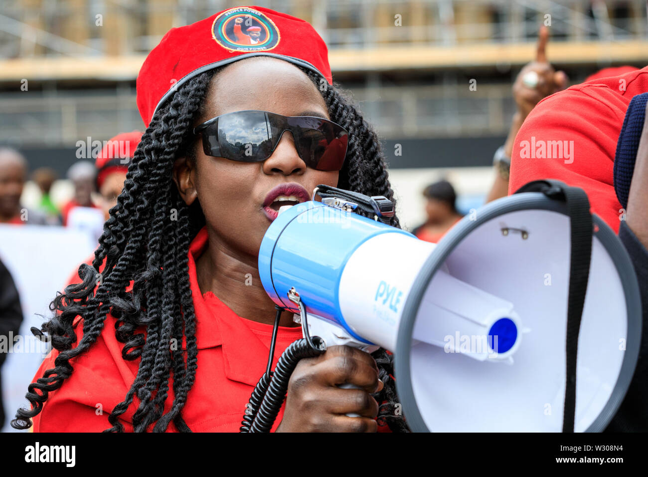 Una femmina manifestante ugandese che manifestano contro il Presidente ugandese Museveni in Londra, Regno Unito Foto Stock