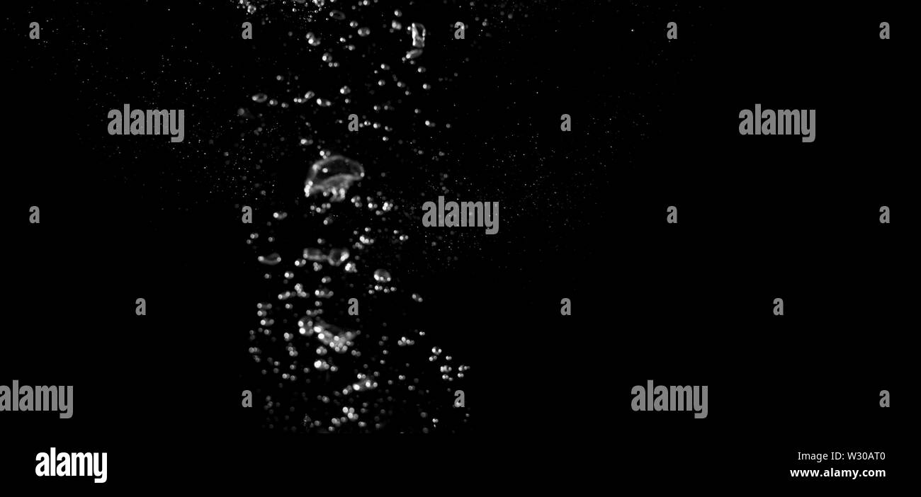 Immagini sfocate di bere acqua bolle di liquido o bevanda di carbonato o forma di olio o di spruzzi di soda e caduta di flottante in sfondo nero per rappresentare s Foto Stock