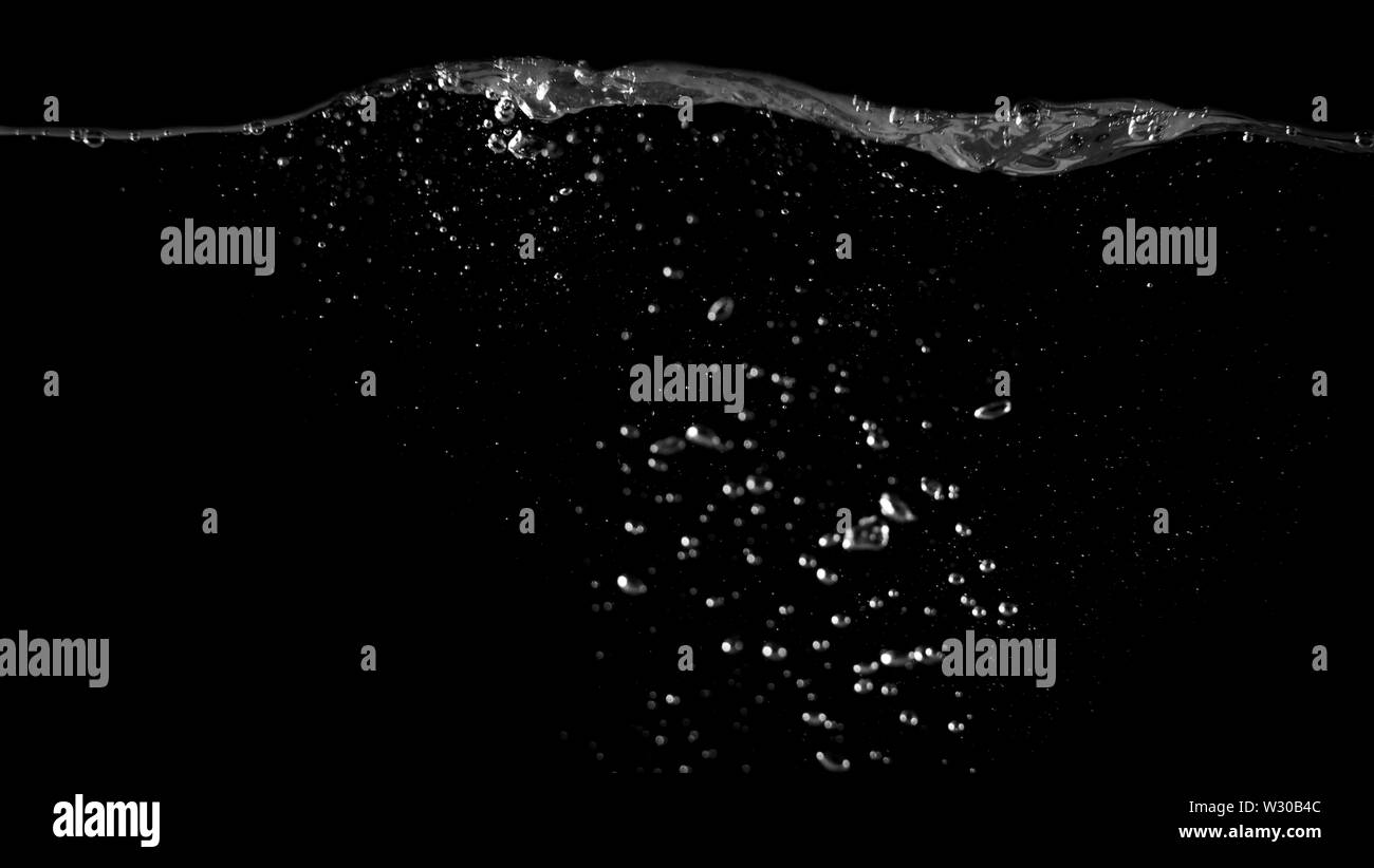 Immagini sfocate di bere acqua bolle di liquido o bevanda di carbonato o forma di olio o di spruzzi di soda e caduta di flottante in sfondo nero per rappresentare s Foto Stock