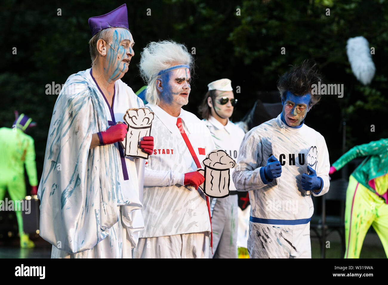 A Mülheim an der Ruhr, Germania. Il 5 luglio 2019. L-R: Rupert J. Seidel, Erich Cherbalth, Fabio Menendez, Mario Neumann. Theater an der Ruhr performes durante la Weiße Nächte stagione in Raffelbergpark Friedrich Dürrenmatt giocare 'Der Besuch der alten Dame' (visita) diretto da Albrecht Hirche. Con Albert Bork (Alfred Ill) e Gabriella Weber (Alte Dame, Claire Zachanassian). Il free open-air spettacoli si svolgono dal 4 al 7 luglio 2019. Foto Stock