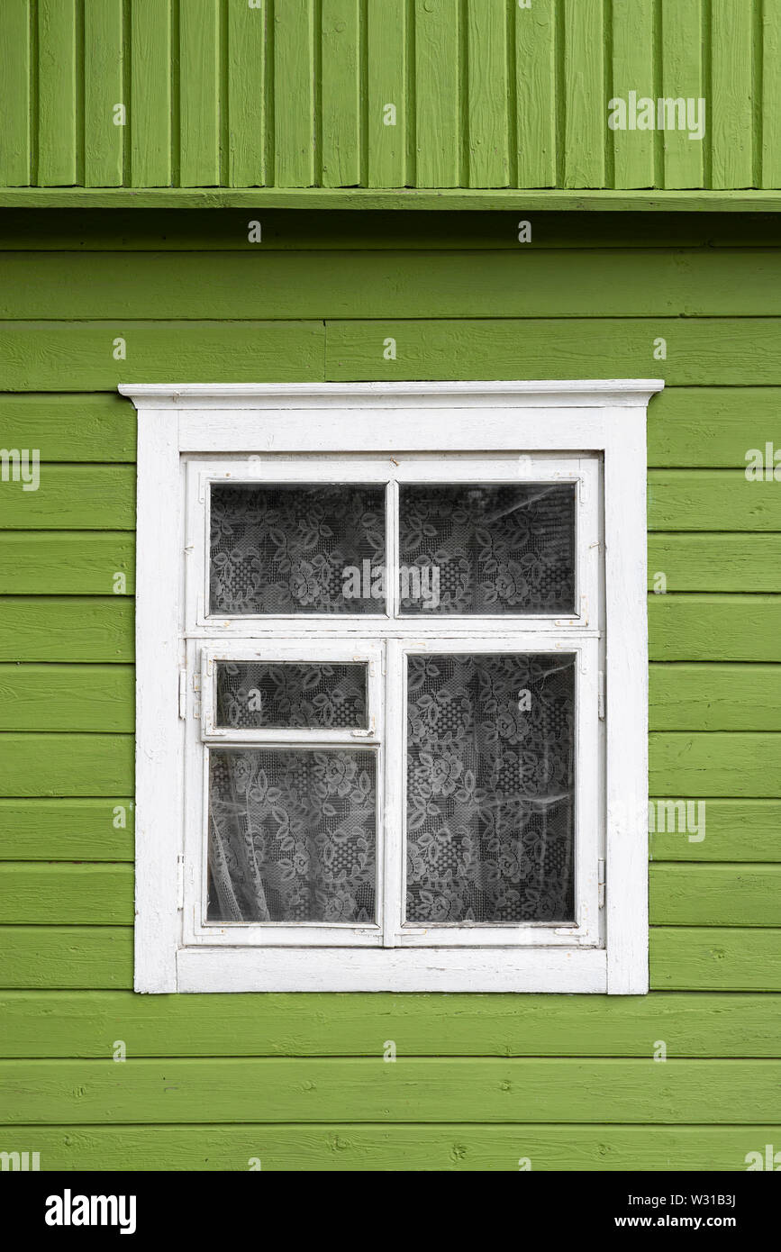 Facciata di edificio con un bianco sul telaio di una finestra e le pareti di colore verde. Foto Stock