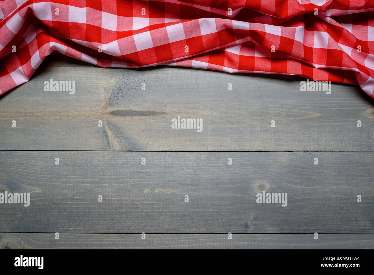 Un controllato gingham tovaglia da picnic sul vecchio tavolo in legno vista superiore Foto Stock