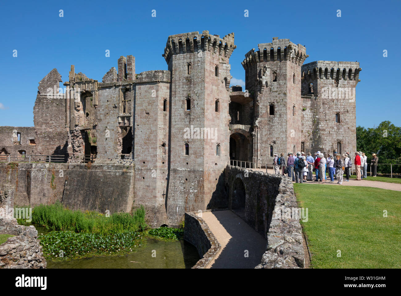 I visitatori di fronte al grande gatehouse a Raglan Castle, Monmouthshire, Wales, Regno Unito Foto Stock