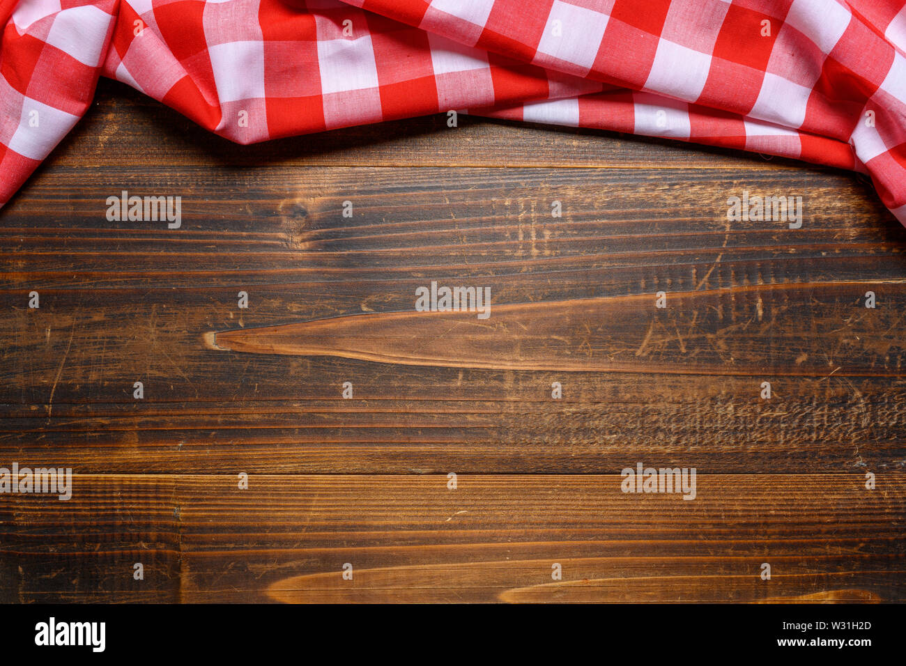 Un controllato gingham tovaglia da picnic sul vecchio tavolo in legno vista superiore Foto Stock