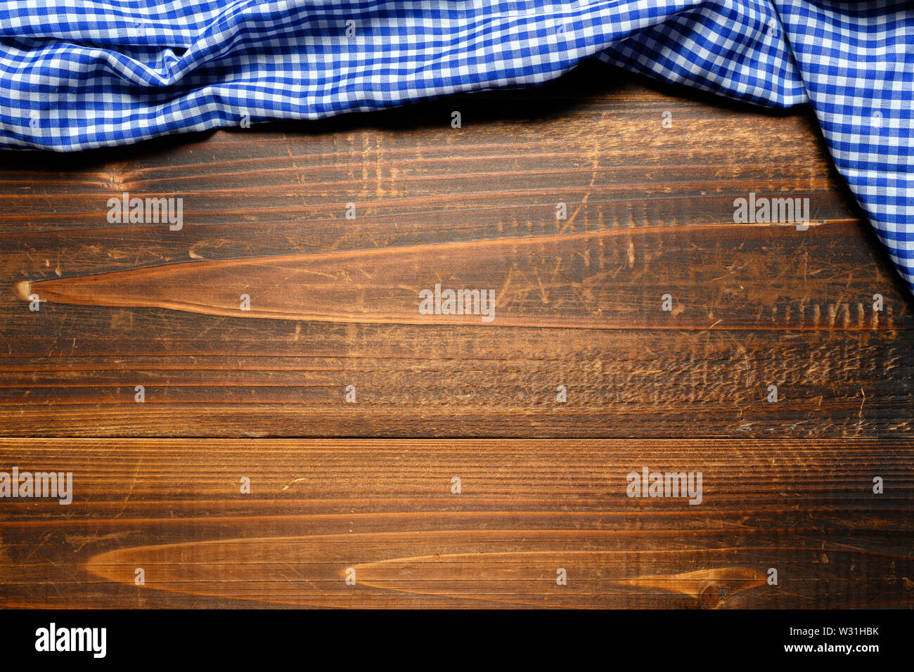 Un controllato gingham tovaglia da picnic sul vecchio tavolo in legno vista superiore Foto Stock