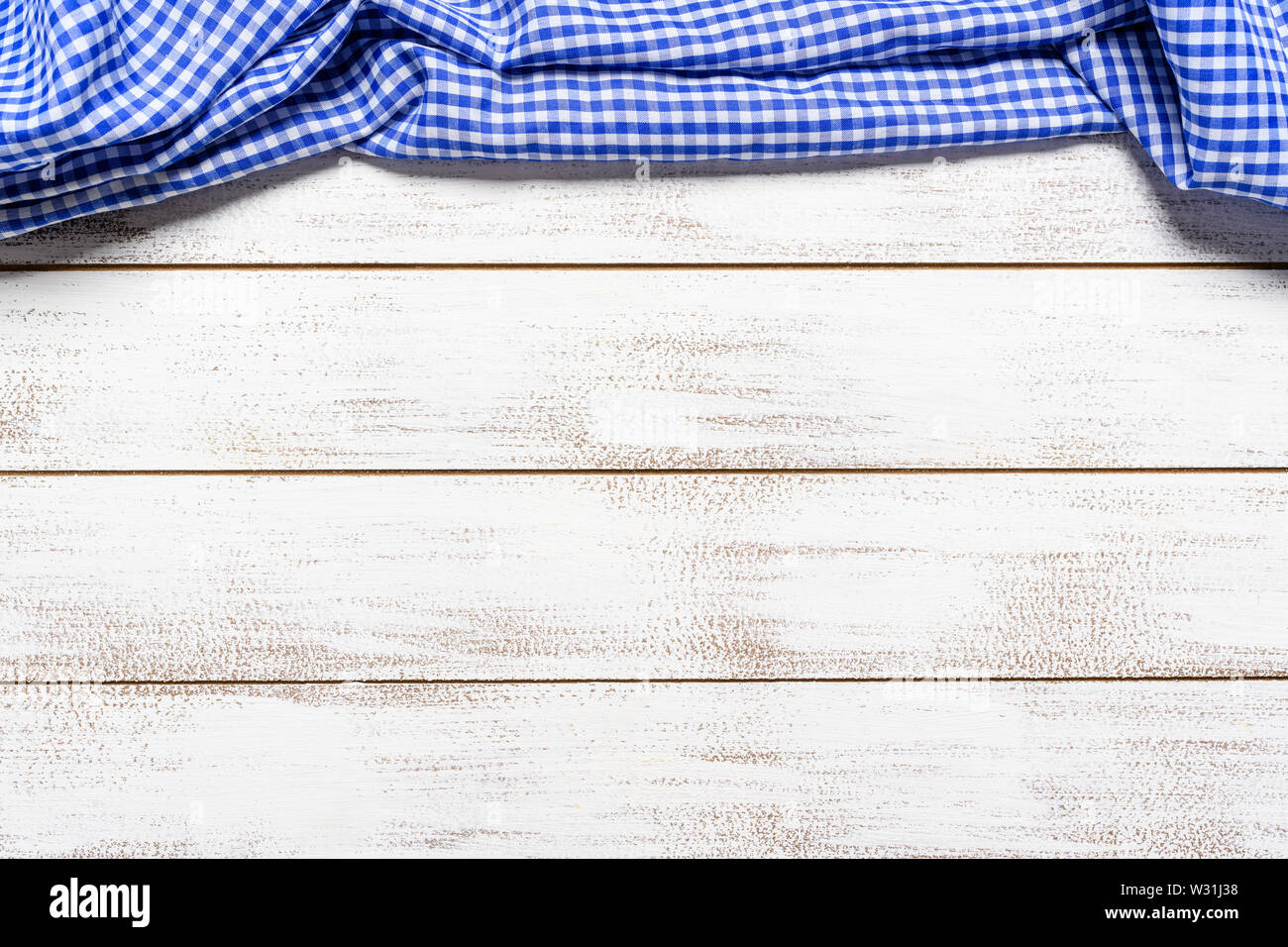 Un controllato gingham tovaglia da picnic sul vecchio tavolo in legno vista superiore Foto Stock