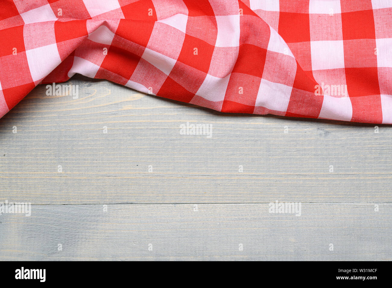 Un controllato gingham tovaglia da picnic sul vecchio tavolo in legno vista superiore Foto Stock