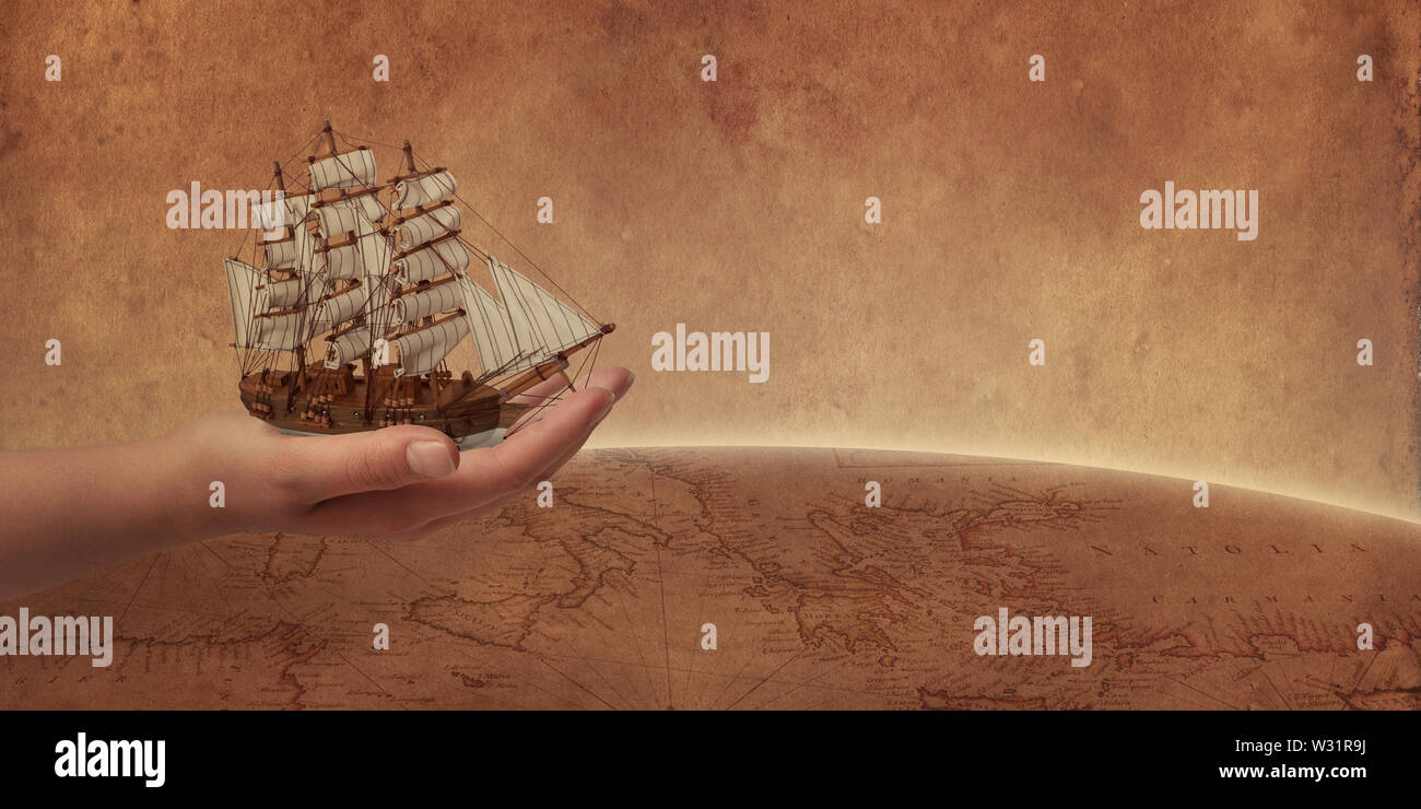 Vecchia nave a vela nel concetto di mano. Retrò mappa del mondo e globo in background. Foto Stock