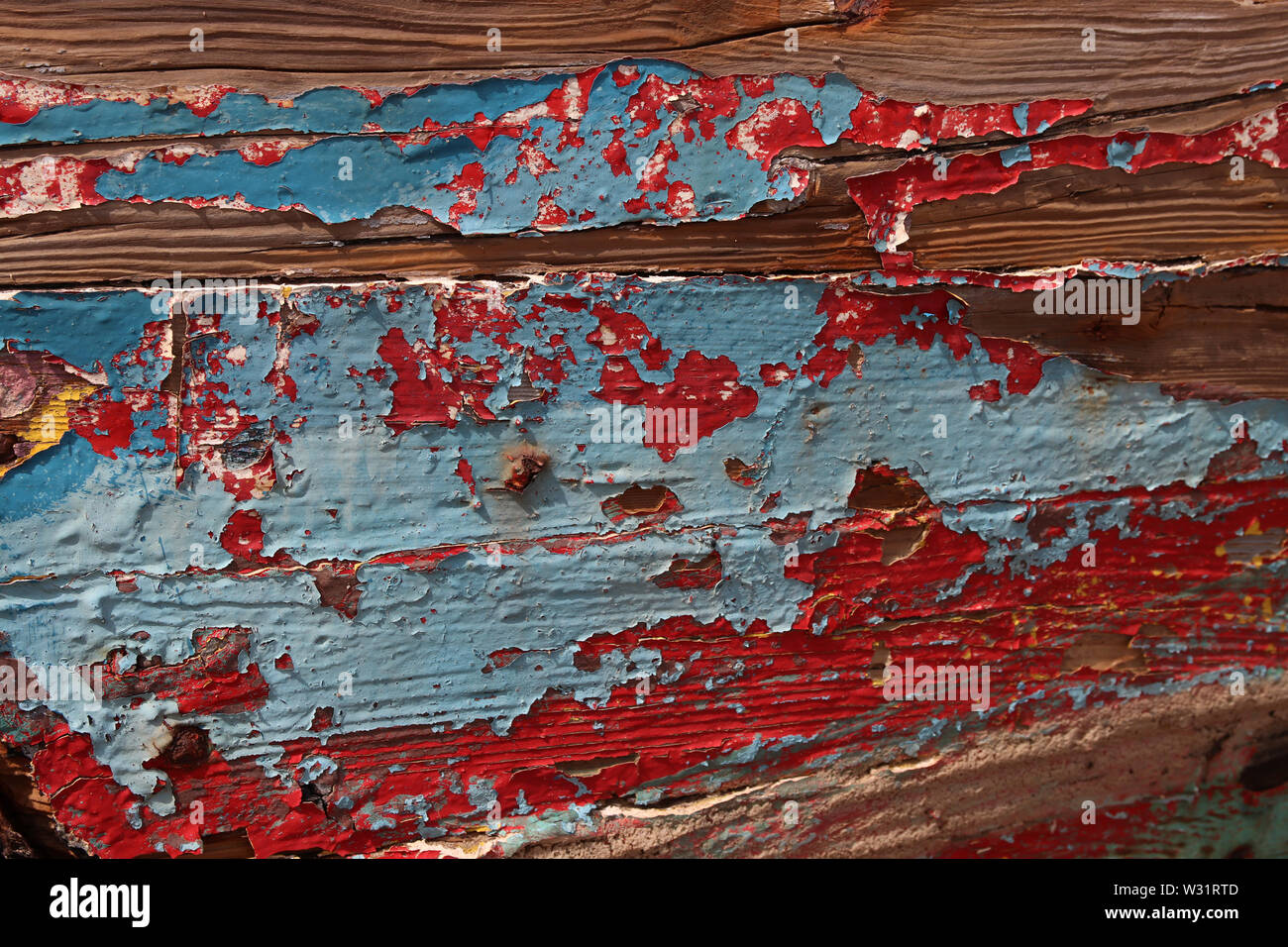 vernice blu e rosso che si stacca su una tavola di legno, sfondo astratto Foto Stock