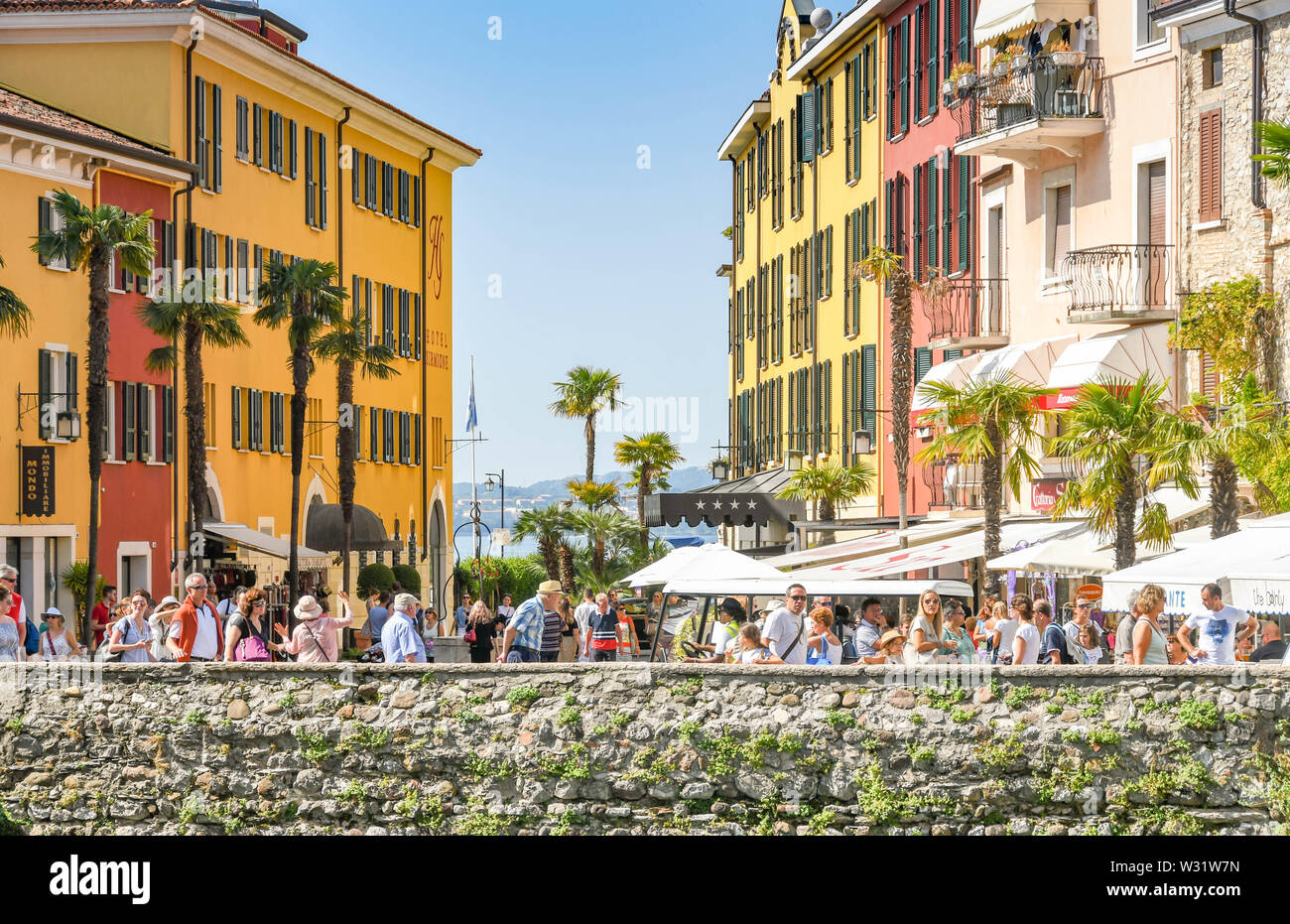 SIRMIONE SUL LAGO DI GARDA, Italia - Settembre 2018: una folla di persone a piedi attraverso Sirmione sul Lago di Garda di fronte edifici colorati Foto Stock