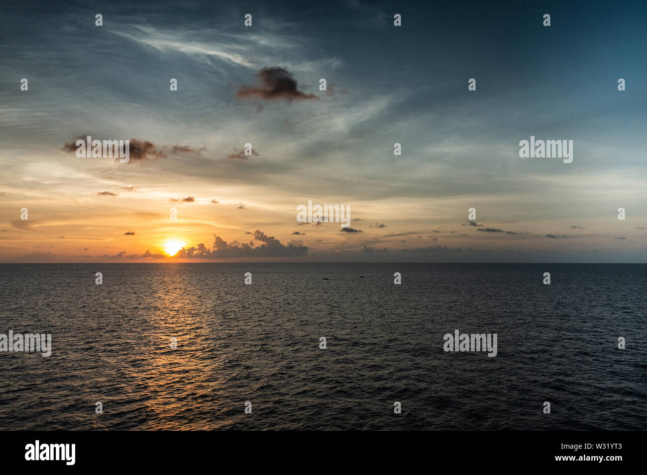 Makassar, Sulawesi, Indonesia - 28 Febbraio 2019: Tramonto oltre lo Stretto di Makassar con pioggia tempesta avvicinando le nuvole. Foto Stock