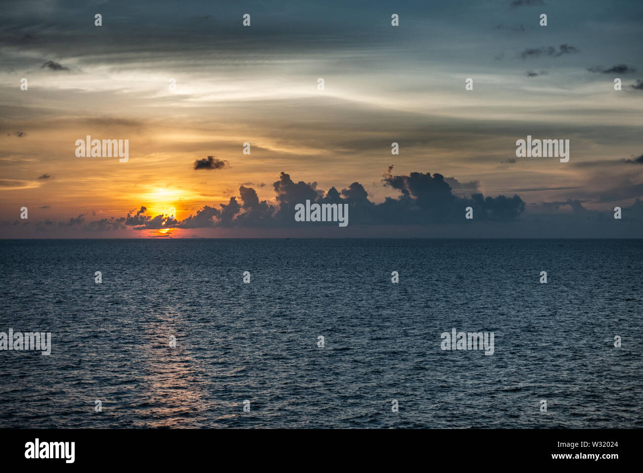 Makassar, Sulawesi, Indonesia - 28 Febbraio 2019: Tramonto oltre lo Stretto di Makassar con pioggia tempesta avvicinando le nuvole. Foto Stock