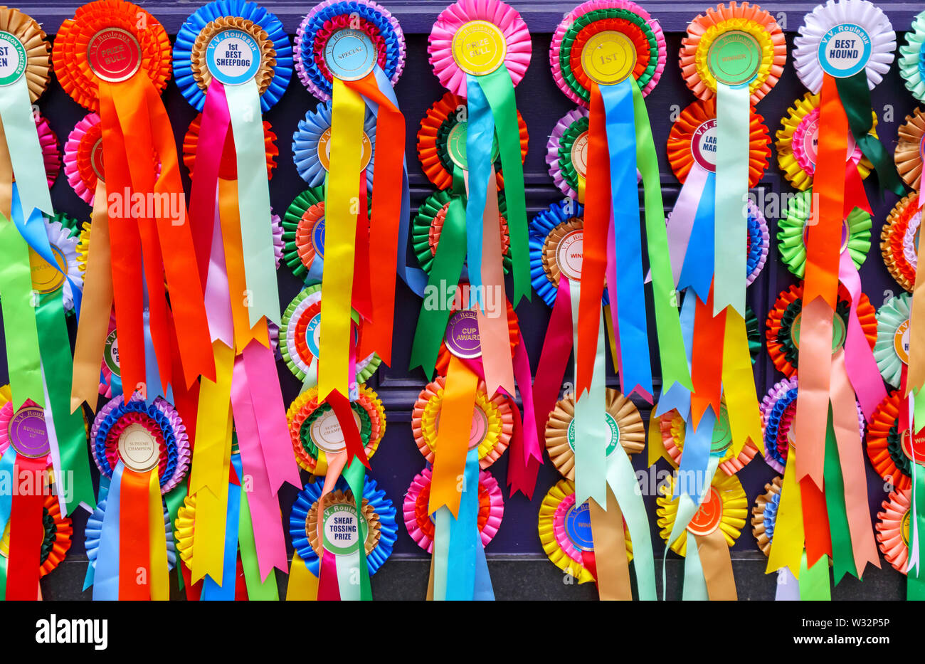 Vivacemente colorato premio e premio rosette e nastri su display al di fuori di un negozio in bagno, la più grande città in Somerset, a sud-ovest dell'Inghilterra, Regno Unito Foto Stock