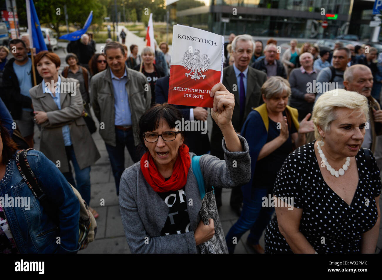 Una donna trattiene una copia della costituzione polacca durante una manifestazione di protesta contro la decisione della procura nazionale su Mariusz Krason, davanti a Cracovia la Corte.Mariusz Krason, Cracovia basa procuratore è stato trasferito a Wroclaw. Egli è stato il promotore di una risoluzione in sede di assemblea generale della direzione regionale dell'Ufficio della Procura di Cracovia, in cui egli ha allarmato dalla minaccia di indipendenza del procuratore europeo. Il 18 luglio, la questione dello stato di diritto in Polonia, ai sensi dell'articolo 7 procedura, verrà discusso nella prossima riunione dei ministri UE. Foto Stock