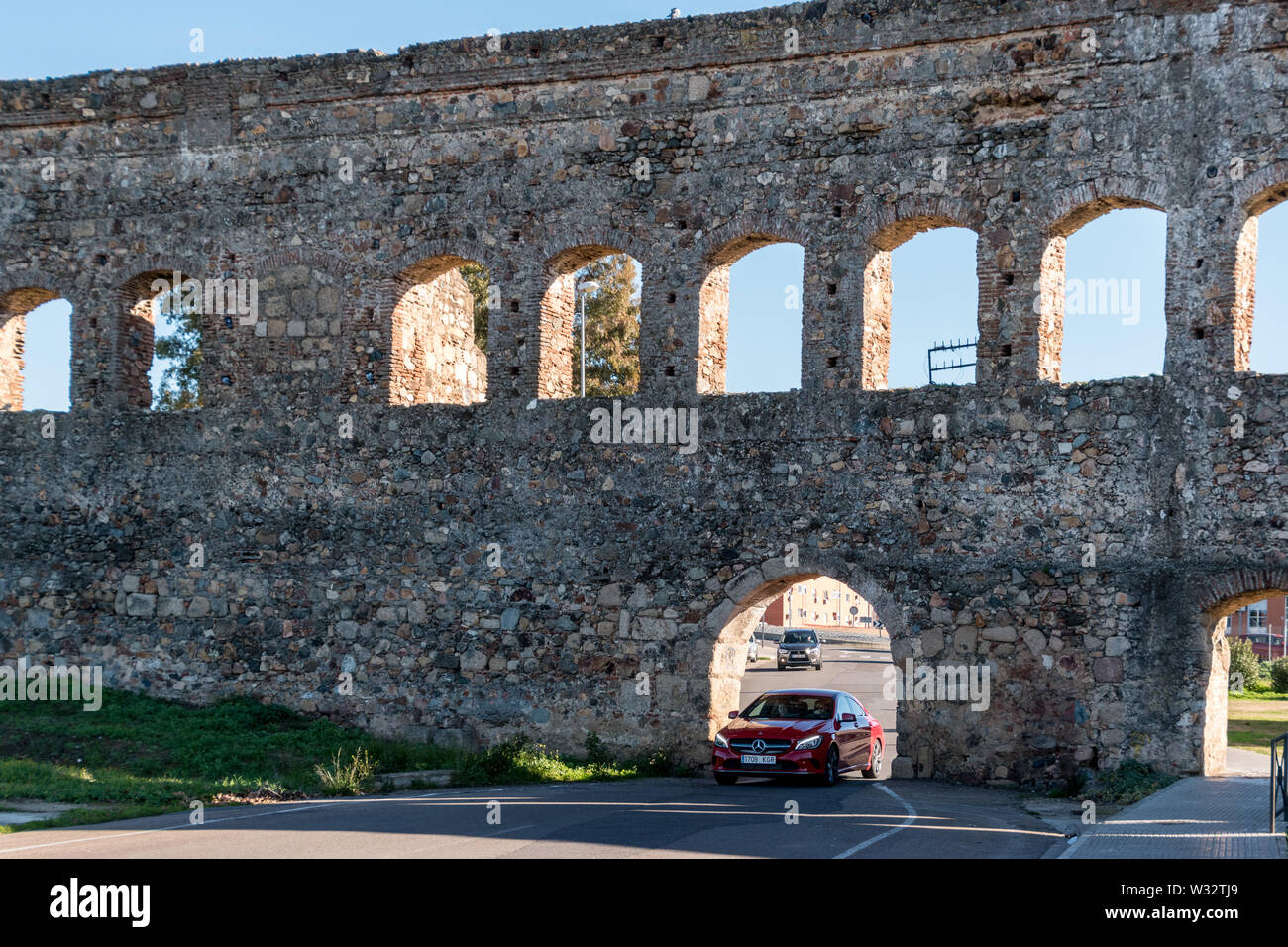 Il vecchio incontra il nuovo: una guida auto attraverso l acquedotto de San Lazaro, un antico acquedotto romano di Merida, Spagna Foto Stock