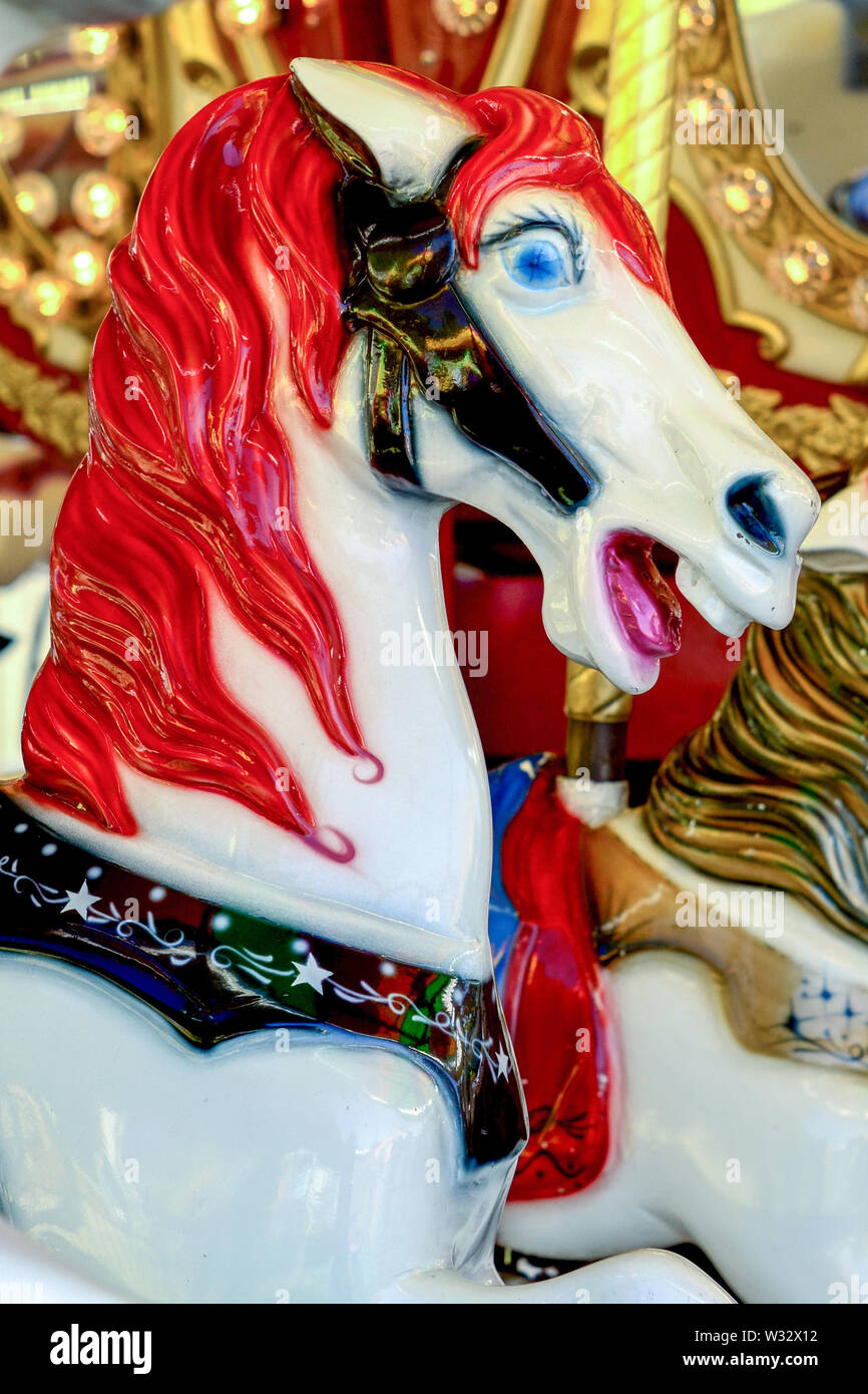 Vista laterale del rosso e del bianco giostra Pony con fondo oro Foto Stock