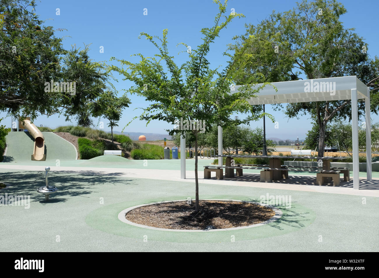 IRIVNE, CALIFORNIA - 11 LUGLIO 2019: Area giochi per bambini nella Bosque Area del Great Park della contea di Orange, con scivoli e giro in mongolfiera in background Foto Stock