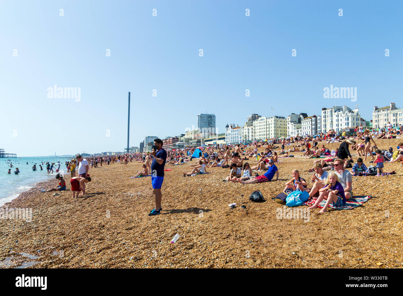 Regno Unito Giugno 29th, 2019 spiaggia di Brighton, Brighton e Hove, East Sussex, Inghilterra. Migliaia di persone rilassarsi su sun. Foto Stock