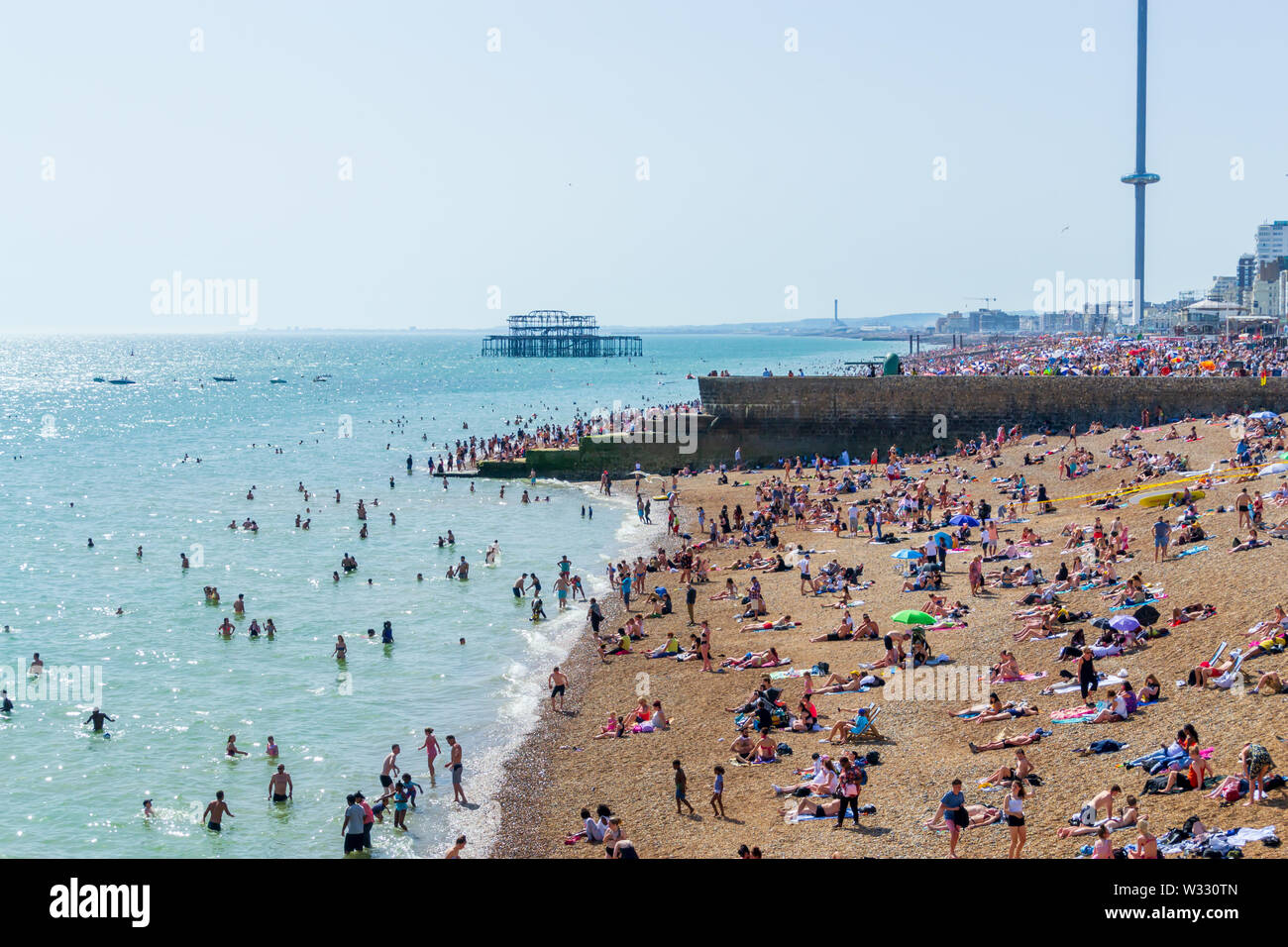 Regno Unito Giugno 29th, 2019 spiaggia di Brighton, Brighton e Hove, East Sussex, Inghilterra. Migliaia di persone rilassarsi su sun. Foto Stock