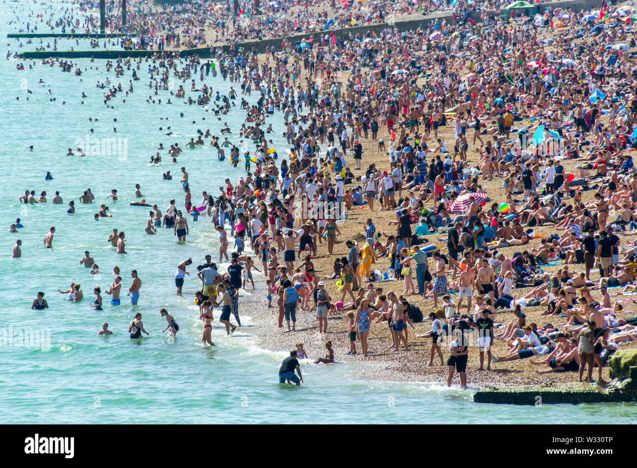Regno Unito Giugno 29th, 2019 spiaggia di Brighton, Brighton e Hove, East Sussex, Inghilterra. Migliaia di persone rilassarsi su sun. Foto Stock