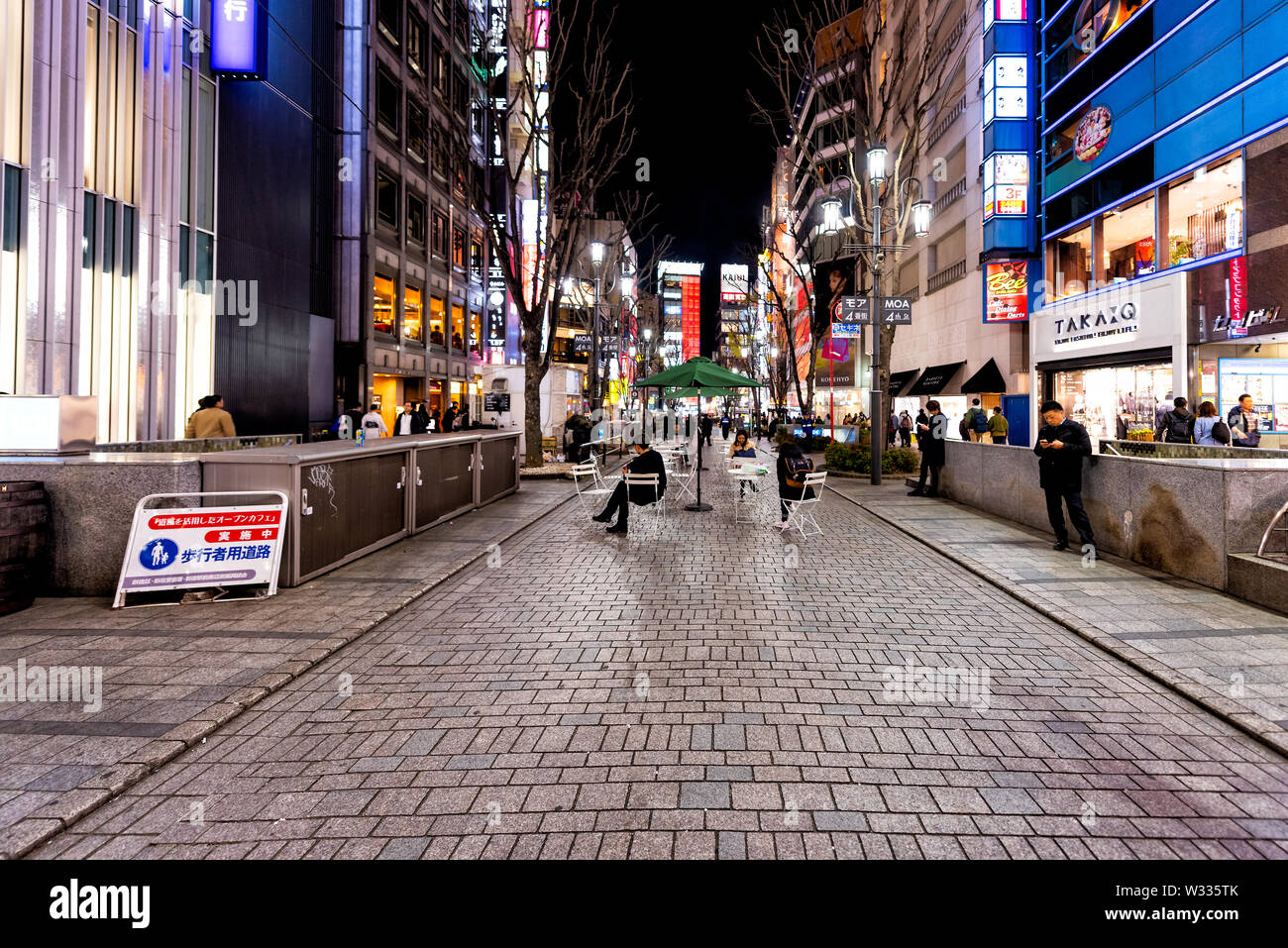 Shinjuku, Giappone - Aprile 4, 2019: MOA quarta strada dalla M quadrato con persone sul marciapiede dal centro commerciale per lo shopping con negozi e botteghe di notte a Tokyo Foto Stock
