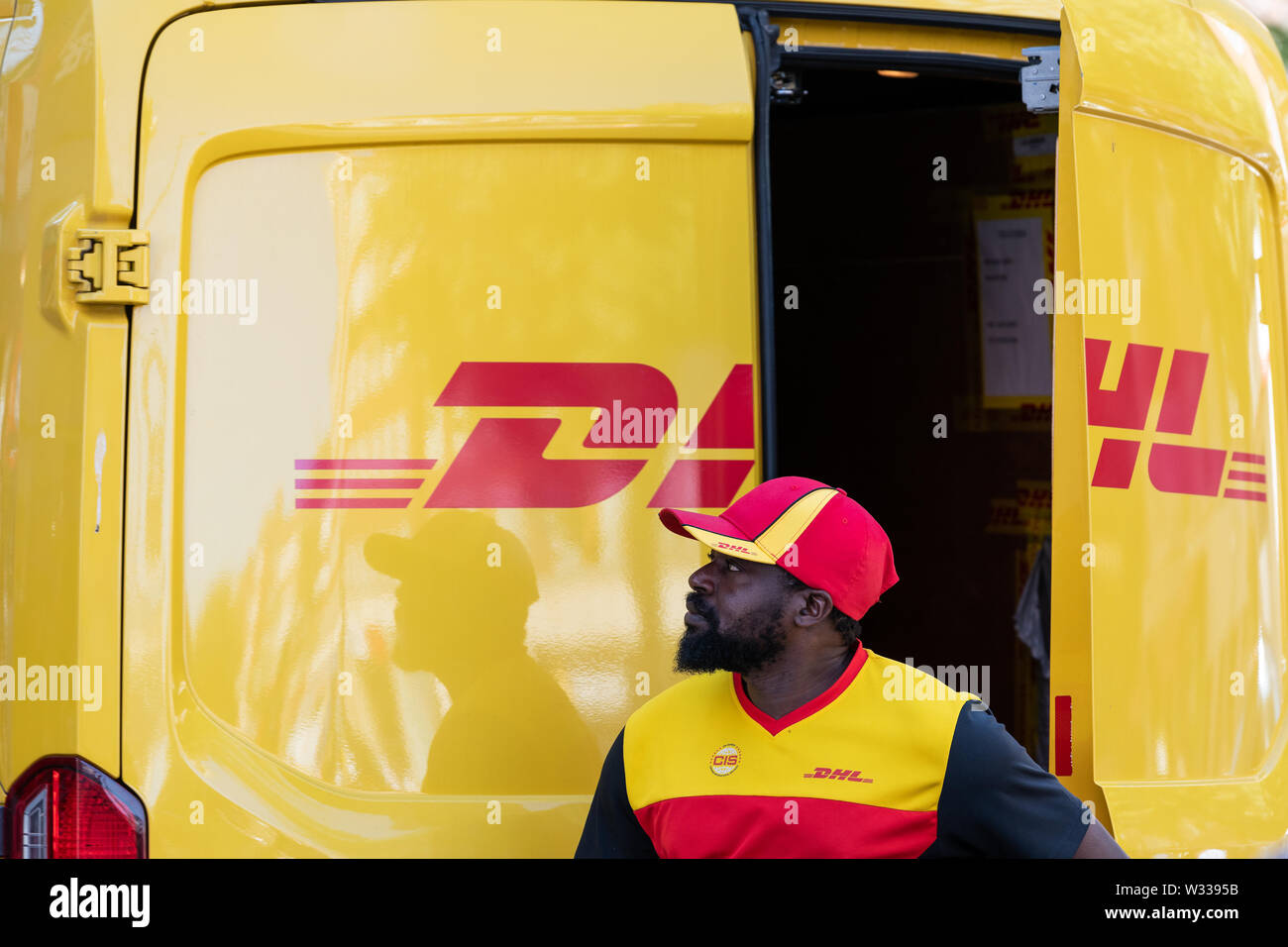 London, Regno Unito - 13 Settembre 2018: primo piano della dhl delivery carrello in Chelsea area della città con l'uomo apertura porta posteriore sulla strada fuori Foto Stock