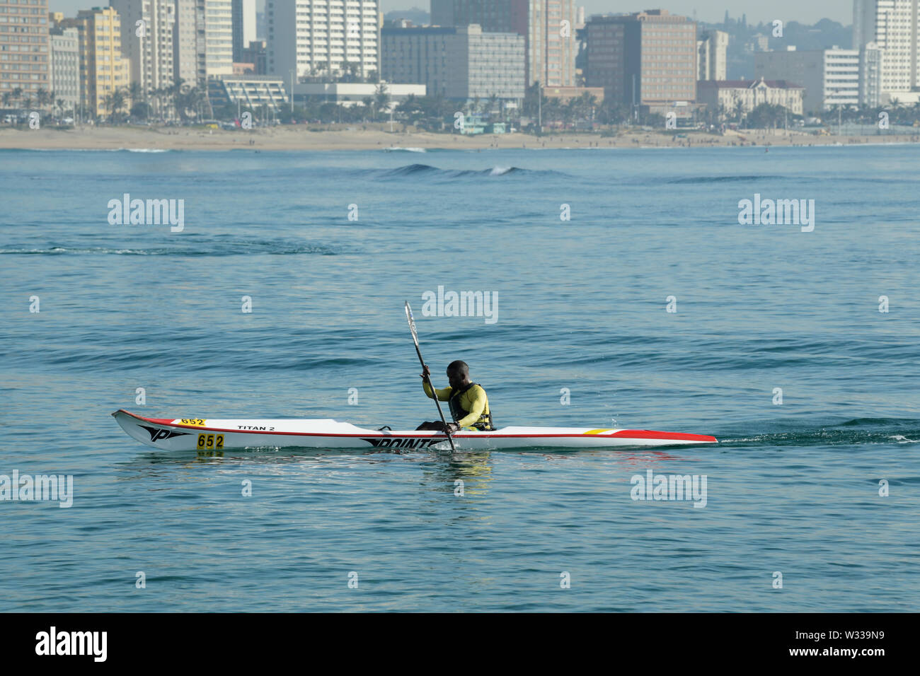 Durban. KwaZulu-Natal, Sud Africa, singolo uomo adulto per sguazzare in canoa surf Ski boat race nella baia di Natal, persone, kayak, sport, paesaggio Foto Stock