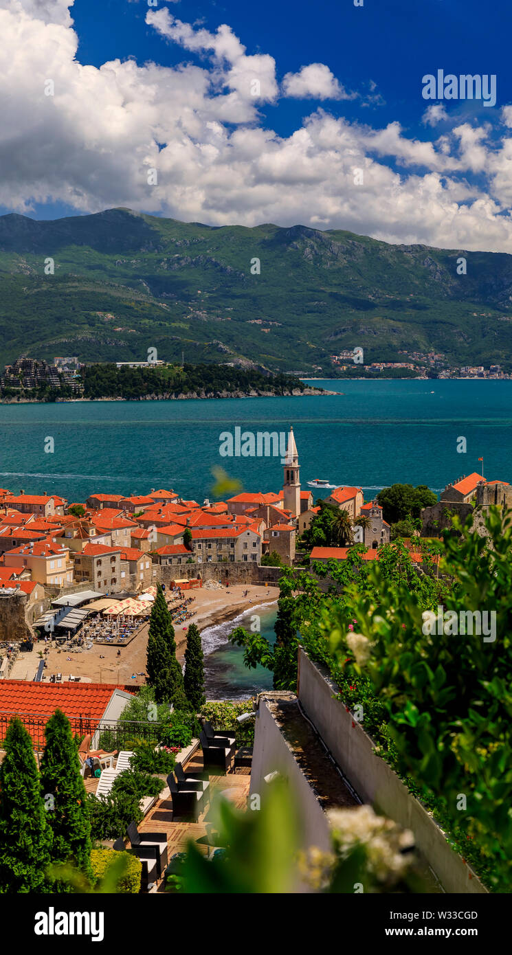 Vista aerea di Budva Old Town con la Cittadella e il Mare Adriatico in Montenegro sui Balcani con fiori in bokeh di fondo in primo piano Foto Stock