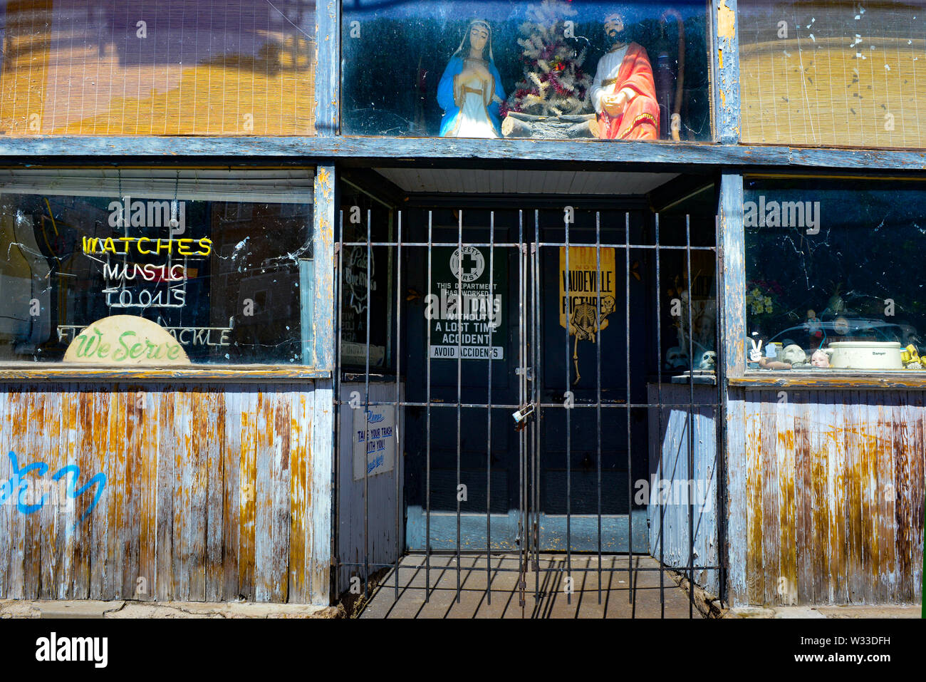 Weathered e apparentemente abbandonato storefront, con evidenza di una varietà di attività precedente, con la scena della natività overhead in bizzarre, Bisbee, AZ Foto Stock