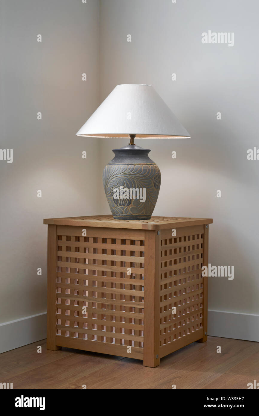 Lampada da tavolo su una scatola di legno in un angolo della stanza Foto Stock