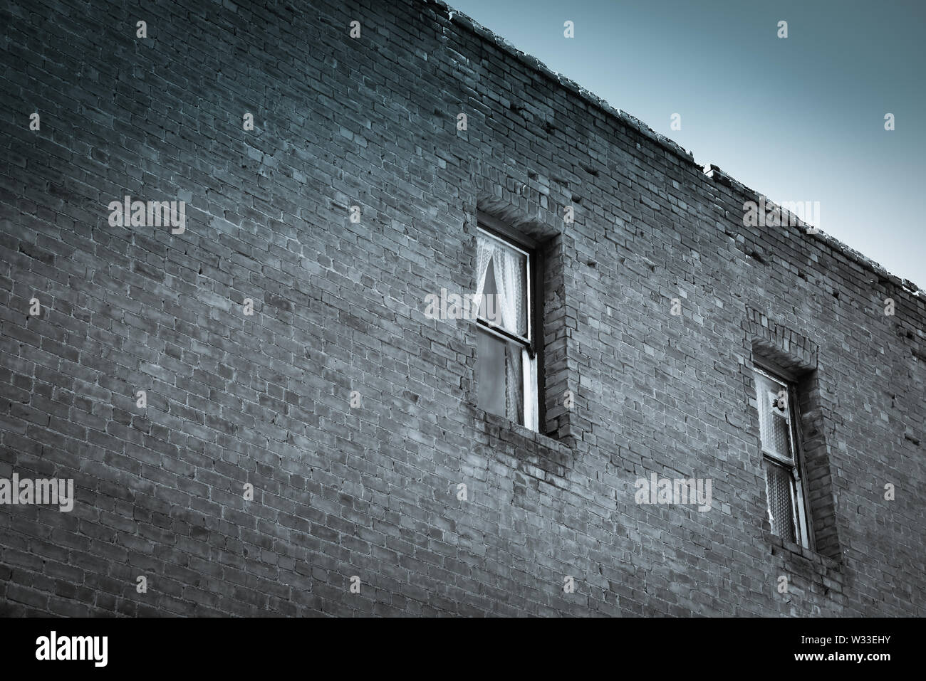 Un spazio negativo la composizione di un secolo il vecchio muro di mattoni di un edificio con windows occupata dal mistero e storia nel sudovest USA Foto Stock