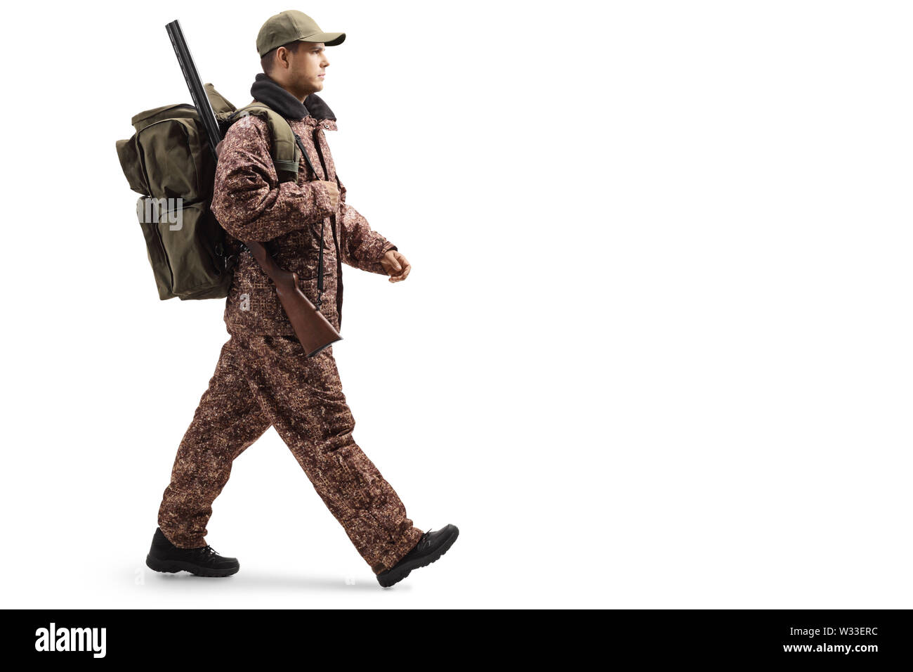Lunghezza piena ripresa di profilo di un cacciatore in un camuffamento uniforme di pochi isolati su sfondo bianco Foto Stock
