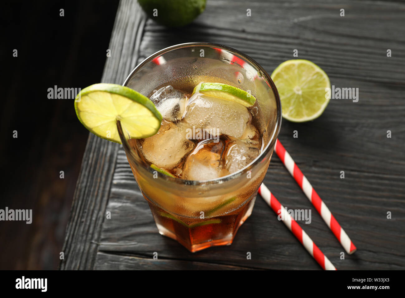 Vetro a freddo cola con agrumi e ghiaccio sul tavolo di legno, lo spazio per il testo Foto Stock