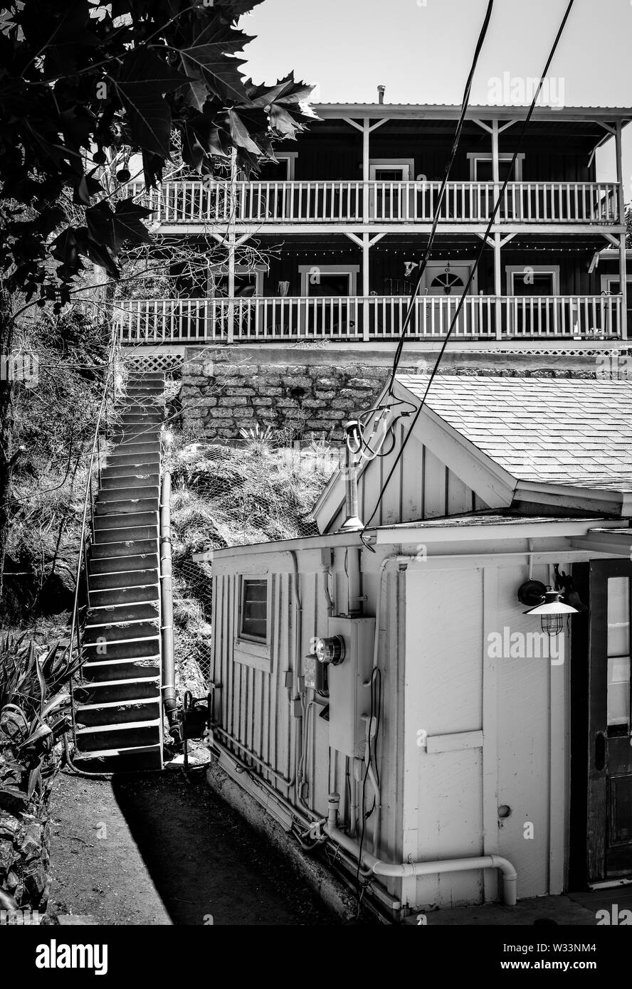 Alcuni wacky scale portano fino a due piani, residence con verande turchese prima di un cottage sulla collina nella vecchia città mineraria di Bisbee, AZ Foto Stock