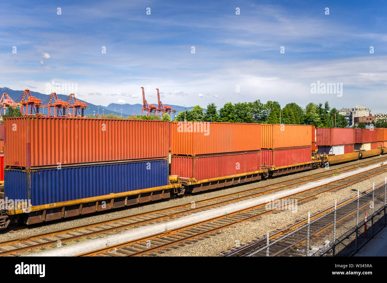 Treno merci caricate con contenitore colorato in un terminal merci Foto Stock