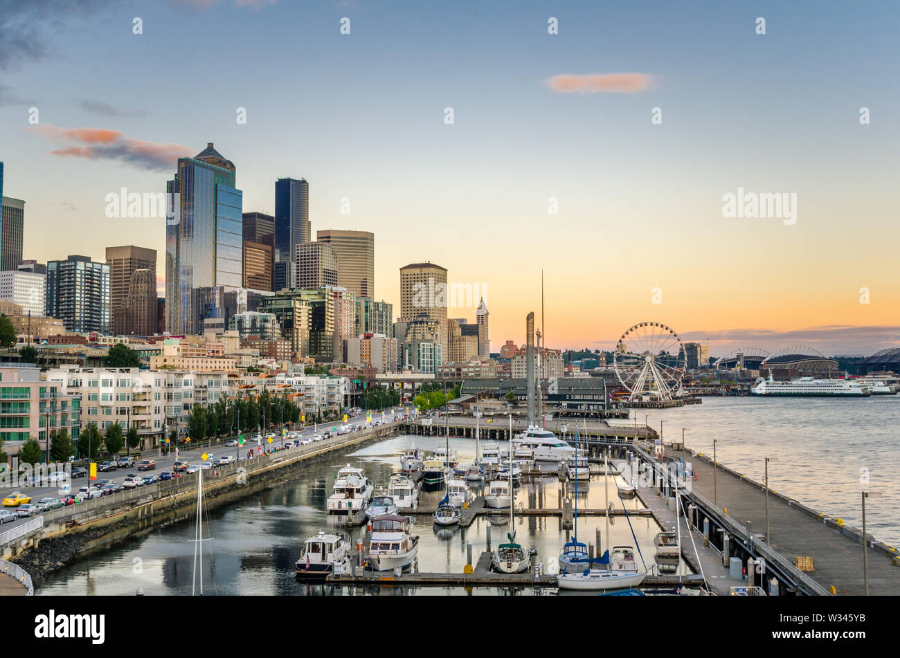 Vista di Seattle Waterfront al crepuscolo. Una marina è visibile in primo piano. Foto Stock