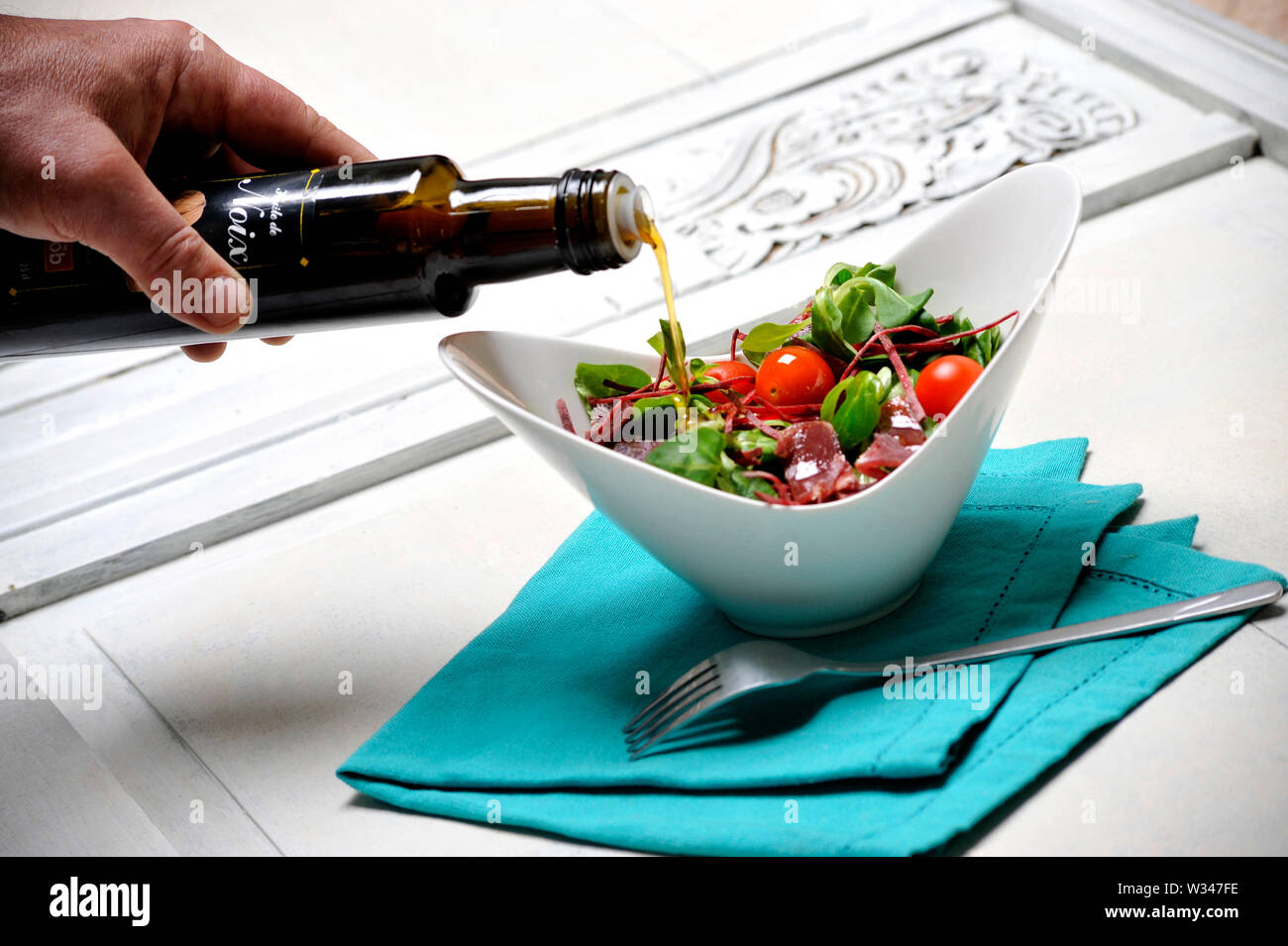Bottiglia di olio di semi di colza come un condimento per insalata Foto Stock