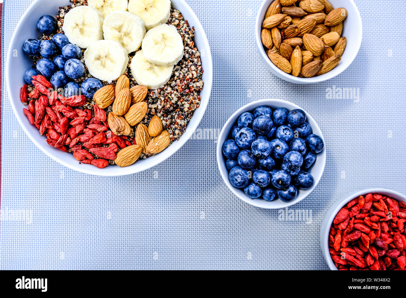 Una sana colazione vegetariana tazza di quinoa con frutta fresca e secca e bacche di Goji Foto Stock